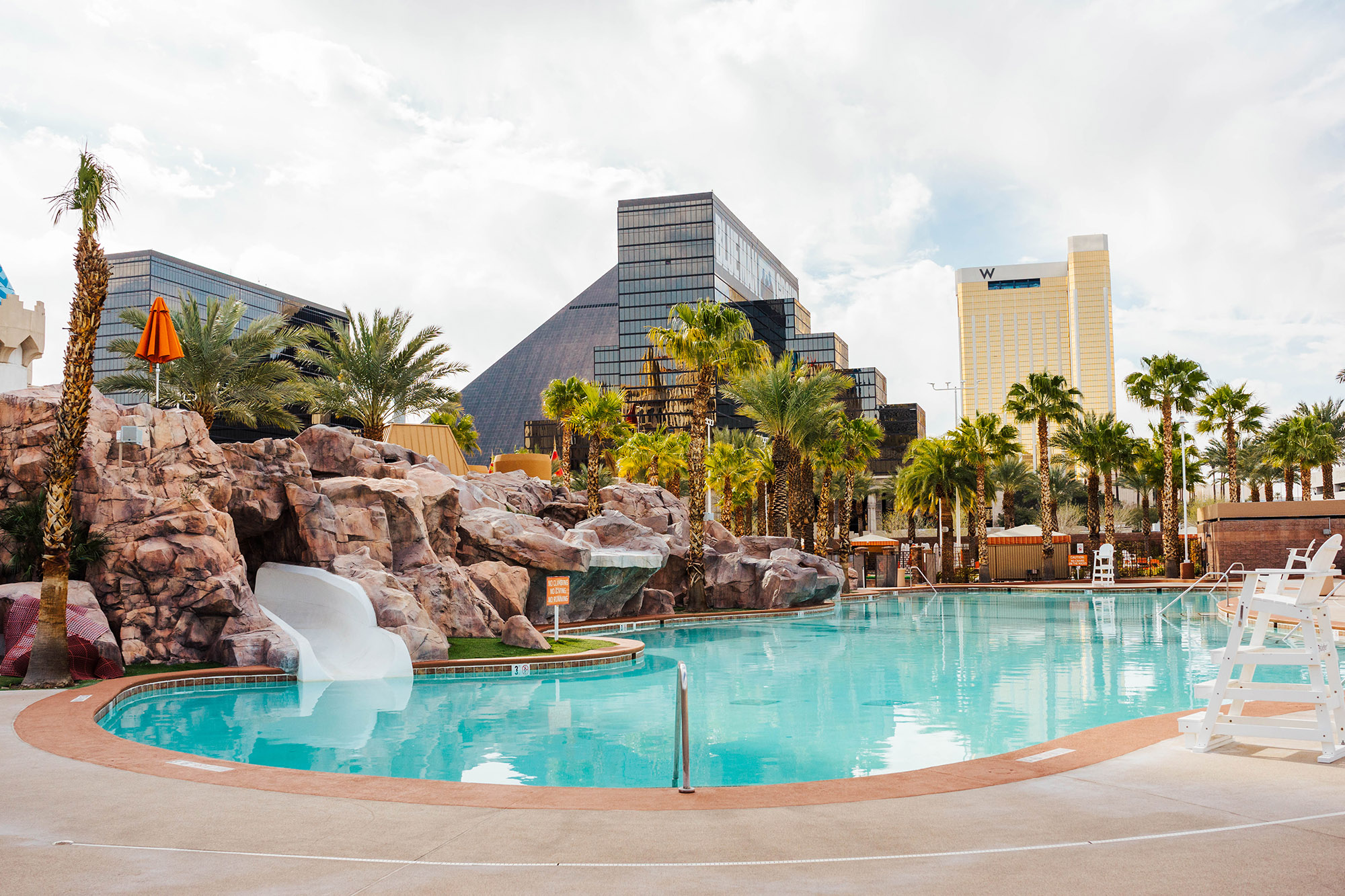 A pool with a waterslide and concrete hardscape at a Las Vegas Resort Hotel - Las Vegas Commercial Pool Service